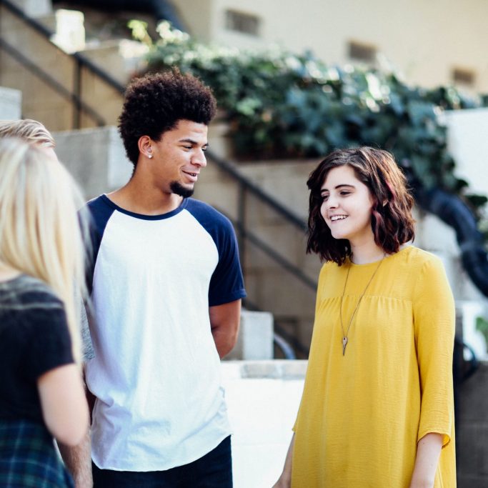 man and women talking outside building man and women talking outside building